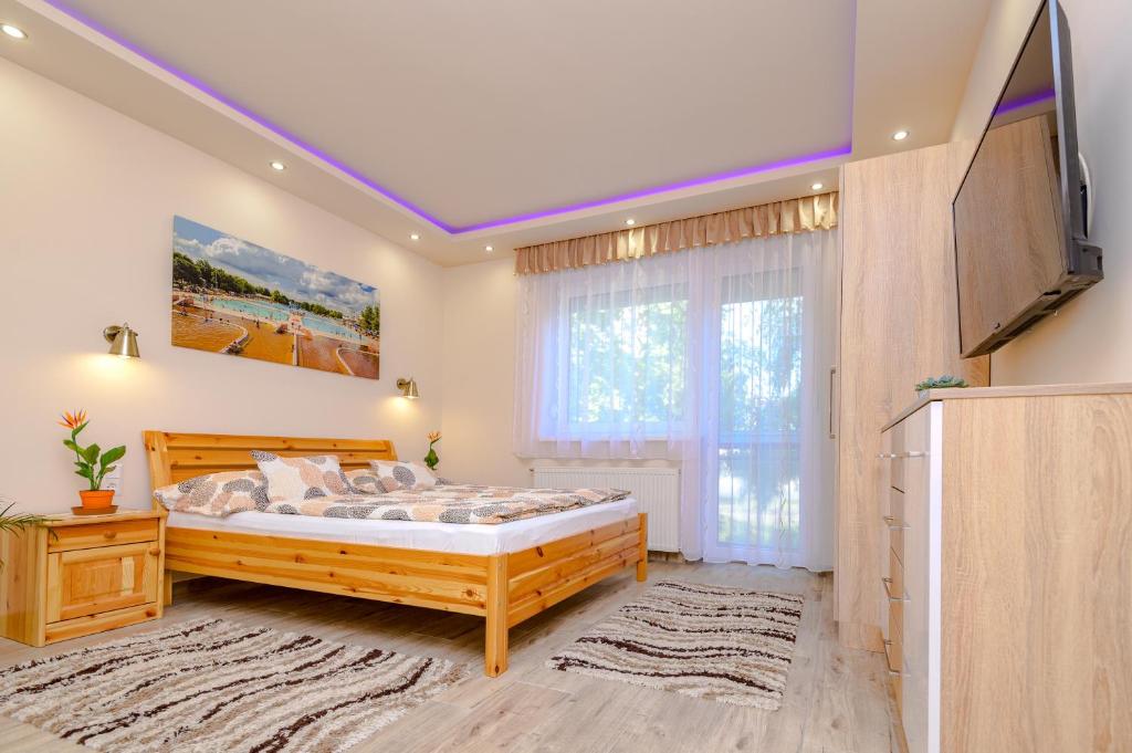 豪伊杜索博斯洛ILLÉS Apartmanok I.的一间卧室配有一张床和一台平面电视