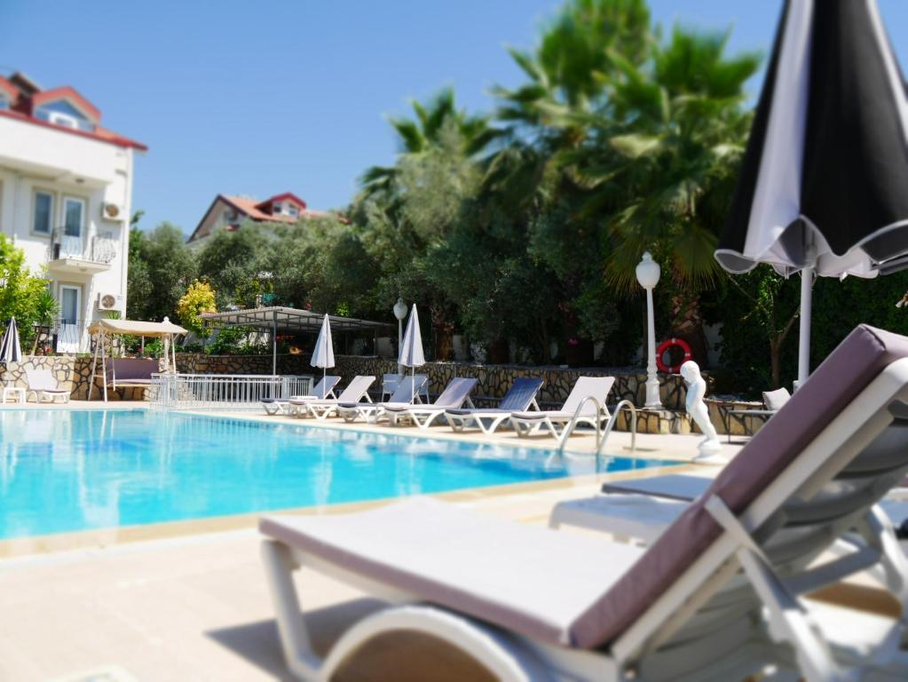 厄吕代尼兹Nefis Hotel Ölüdeniz的一个带躺椅和遮阳伞的游泳池
