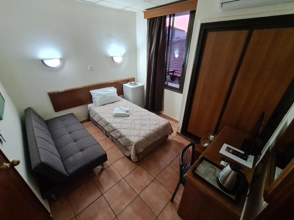 利马索尔梅特罗波尔酒店的小房间设有床和沙发