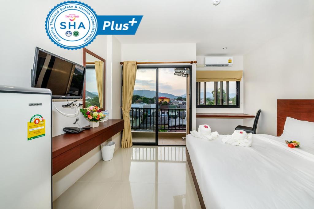 普吉镇The Topaz Residence Phuket Town的一间酒店客房,设有两张床和电视