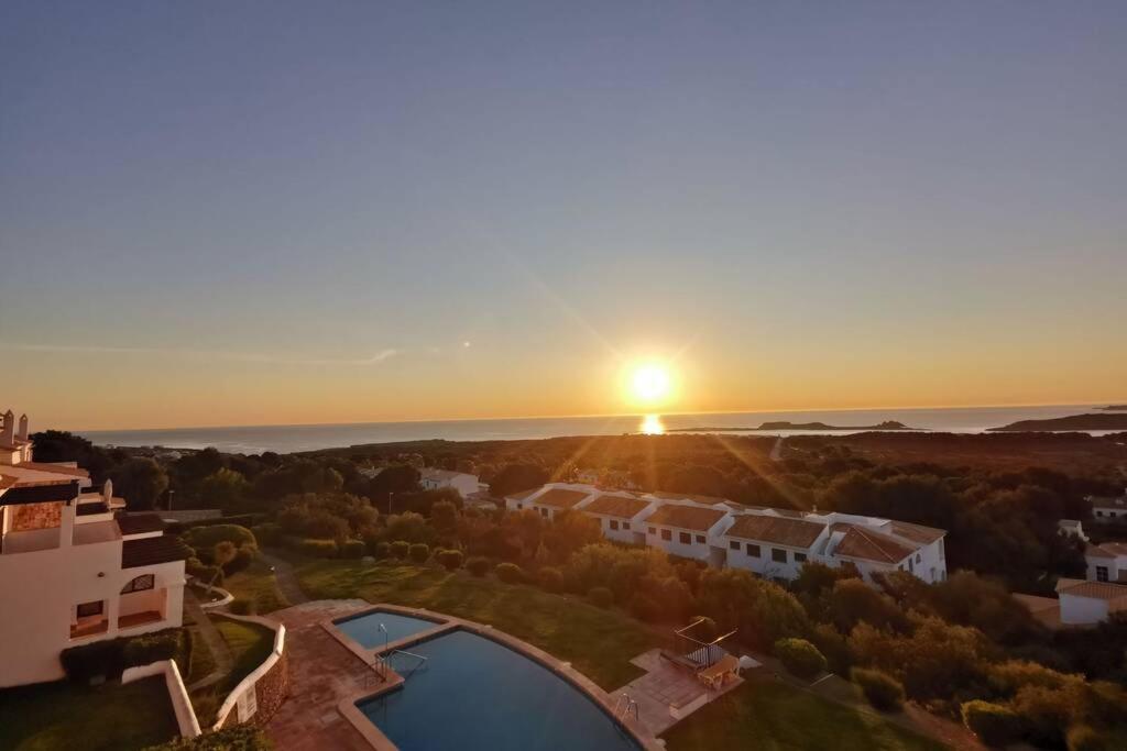 埃斯·梅卡达尔V. Lona: beautiful duplex with a stunning seaview的享有房子的空中景色,背景是日落