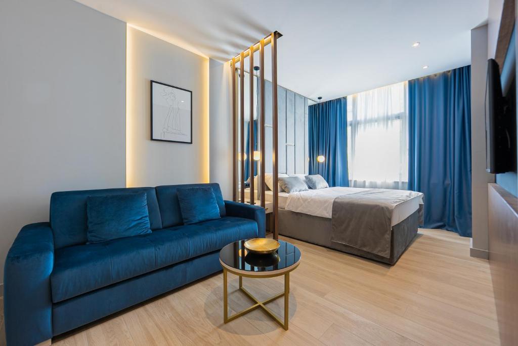 斯普利特Caldo Luxury Rooms的客厅配有蓝色的沙发和床。
