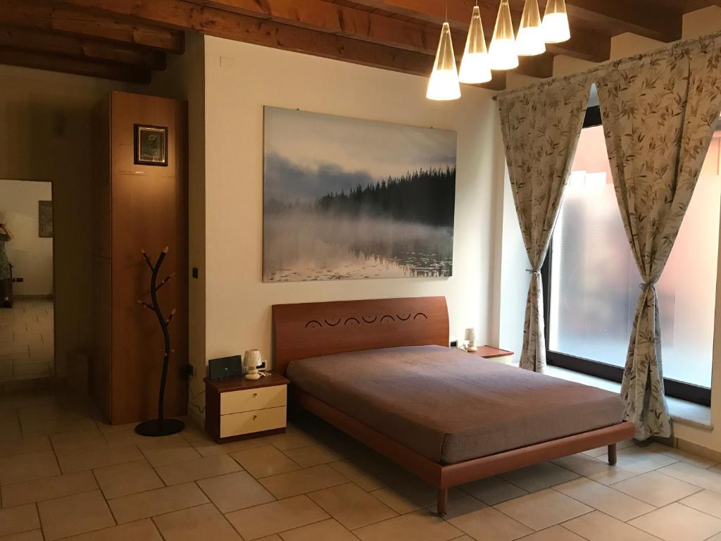 佩斯基耶拉德加达KINDLY ROBERTA centro storico Peschiera,lago relax的一间卧室设有一张床和两个大窗户