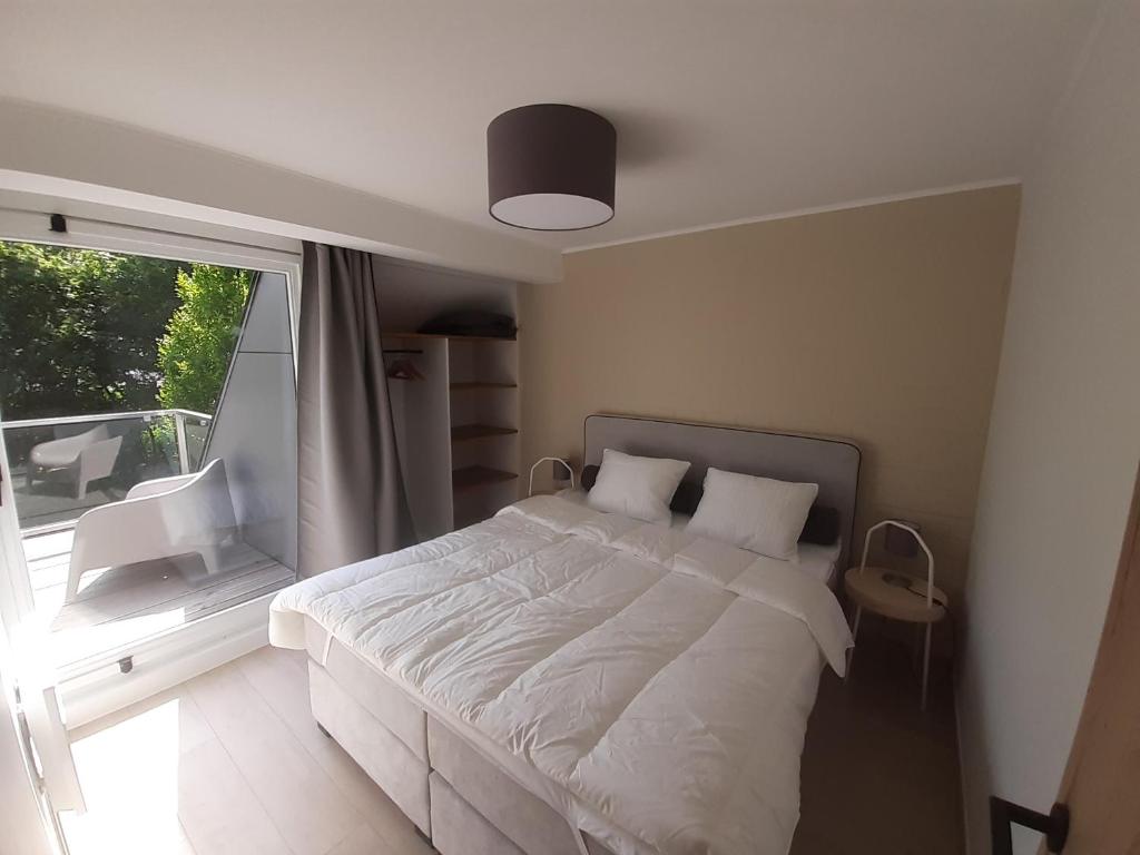 维尔雅尔姆Bee Tree Appartement的卧室配有白色的床和窗户。