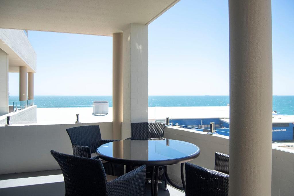 珀斯Cottesloe Beach View Apartments #7的海景阳台上的桌椅