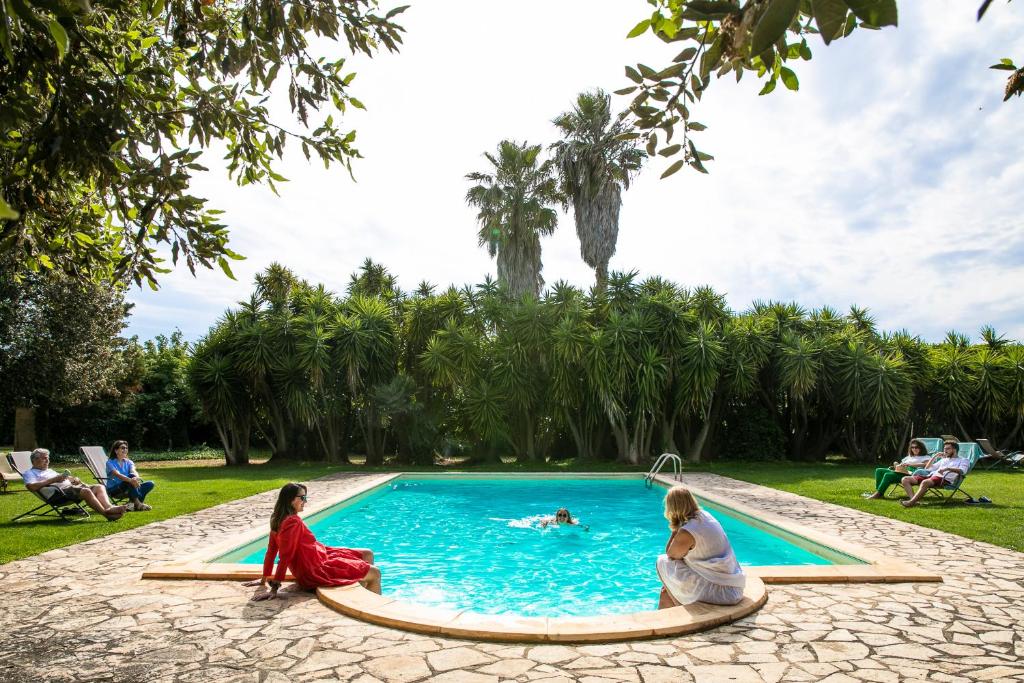 布林迪西马塞利亚巴尼努维酒店的一群人坐在游泳池周围