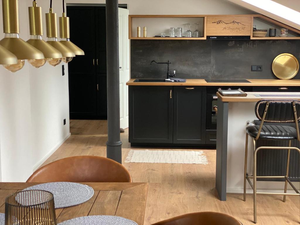 特劳恩施泰因Am Lenzensberg 667 - Neu mit E-Ladestation的厨房配有黑色橱柜和桌椅