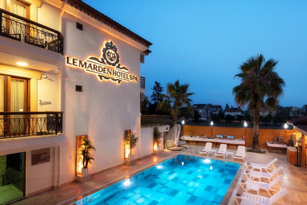 特基罗瓦Le Marden Hotel Spa的大楼前设有游泳池的酒店