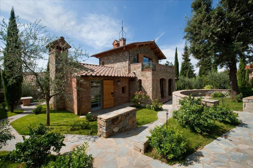 皮安迪斯科Fattoria Casamora - Villa La Leccina的一座大型石头房子,前面设有一个花园