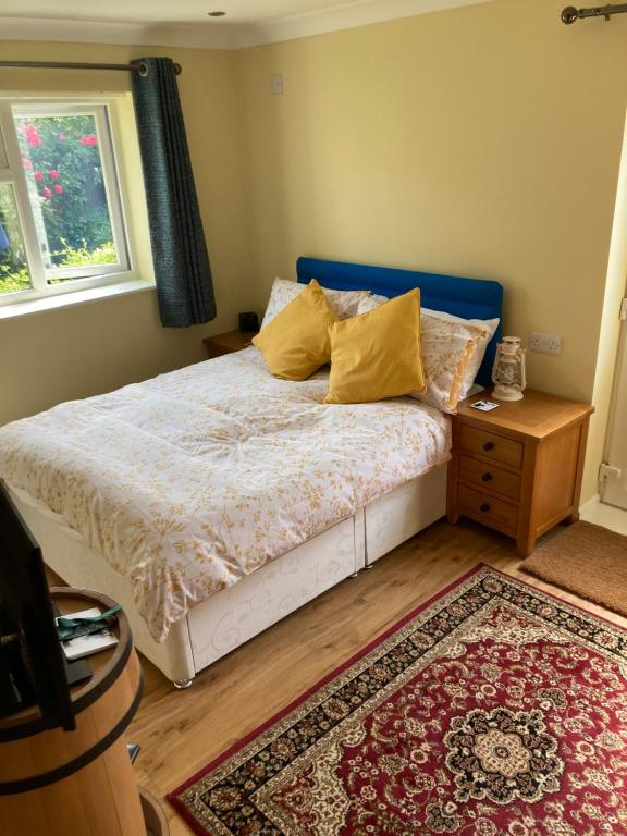 BrundallThe Buttery的一间卧室配有一张带黄色枕头和地毯的床