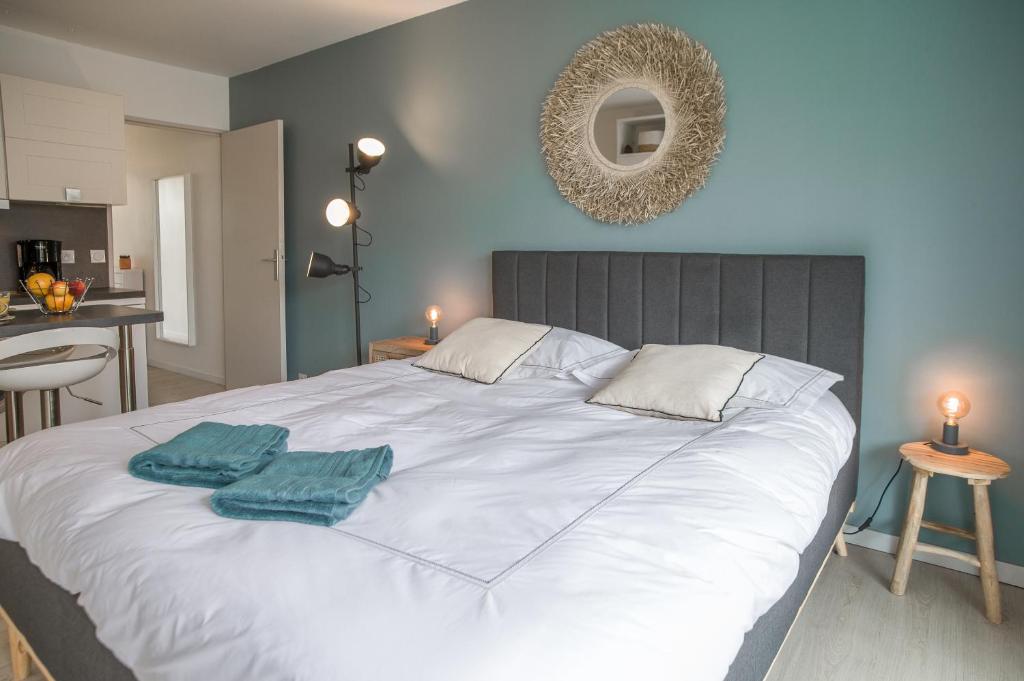 阿卡雄La Pomponnette du Bassin的一间卧室配有一张大白色床和两个枕头