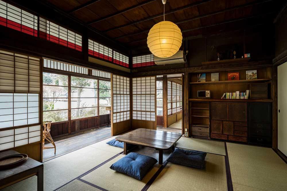 叶山町平野邸 Hayama的带桌子的客房位于带窗户的房间内