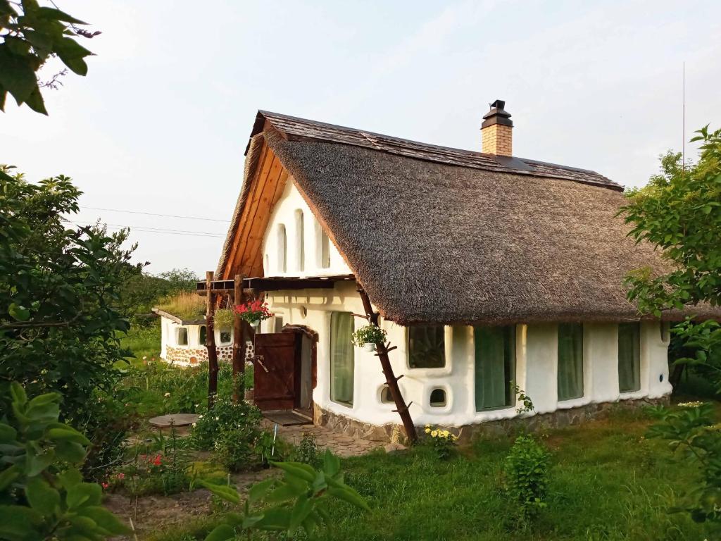 BukiСказочный Дом (Fairy House)的白色的小小屋,设有茅草屋顶