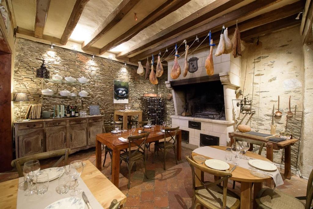 昂瑟尼L'Hotellerie de la Toile à Beurre的一间带木桌的用餐室和一间厨房