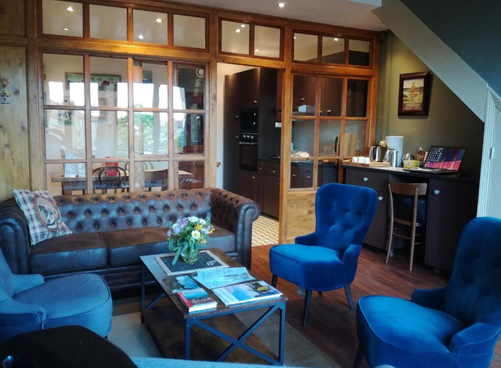 PradellesGîte les 4 Vents的客厅配有沙发和蓝色椅子