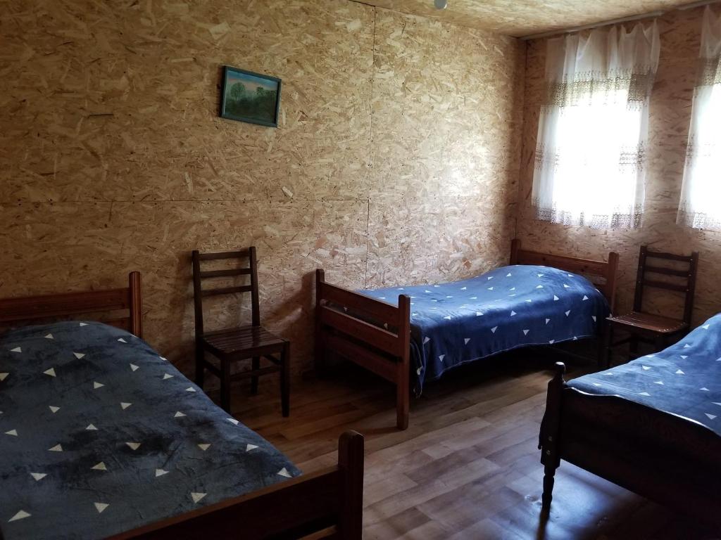 AkhmetyMakratela的客房设有两张床、椅子和窗户。