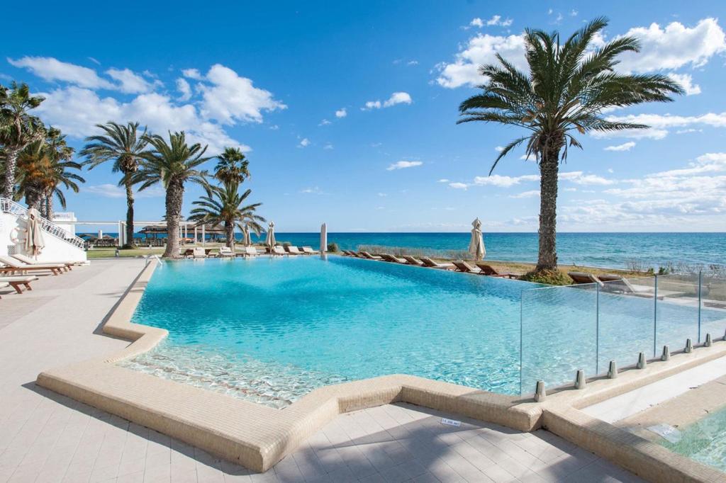 哈马马特贝拉祖尔特拉所简易别墅酒店的一座棕榈树和海洋游泳池