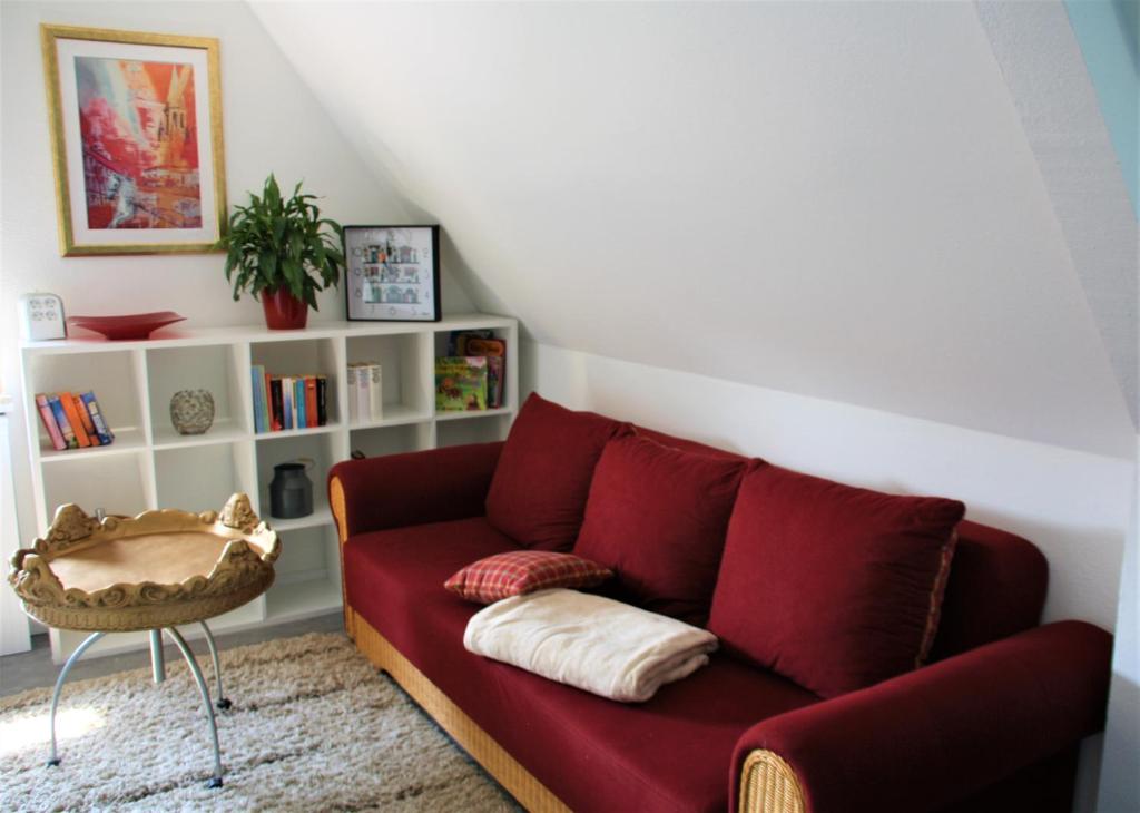 拉斯特德Ferienwohnung Heimelich的客厅配有红色沙发和书架