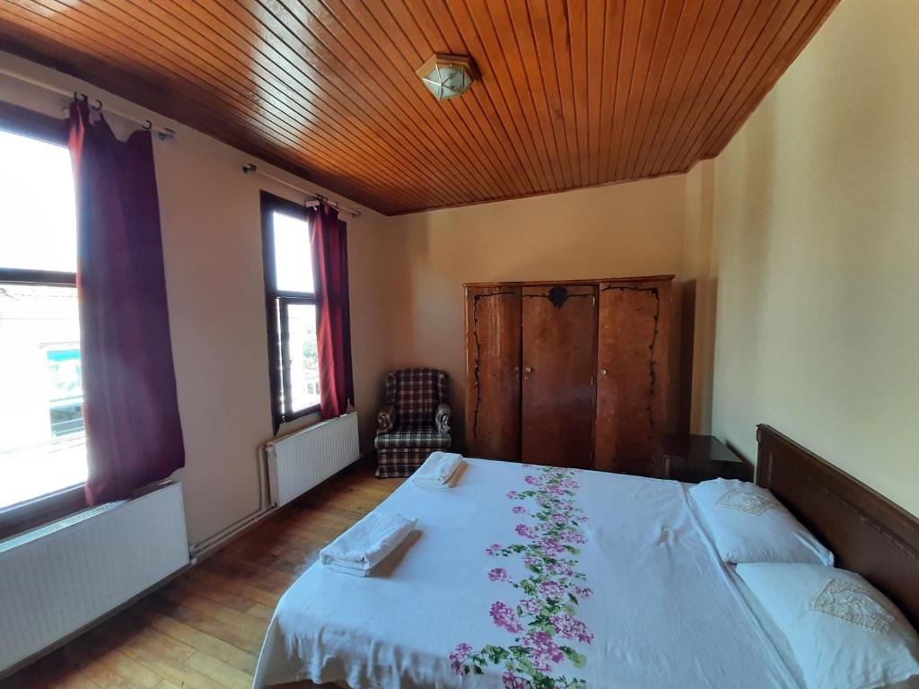 雷贝里岛Manzaraada Merkez的一间卧室配有一张带白色床罩和鲜花的床。