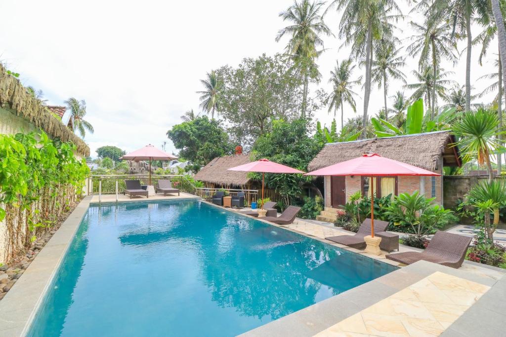 圣吉吉Senggigi Cottages Lombok的度假村的游泳池,配有椅子和遮阳伞