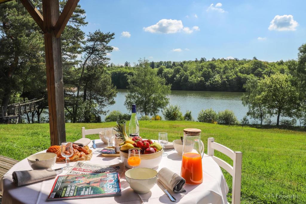 Meyrignac-lʼÉgliseVacancéole - Le Domaine des Monédières的一张桌子,上面放着食物,享有湖景