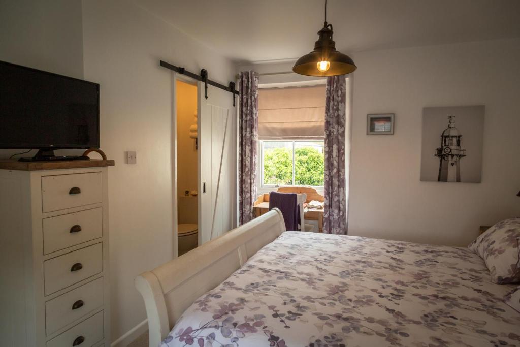 梅瓦吉西梅瓦吉赛石头小屋旅馆的一间卧室设有一张床、一台电视和一个窗口。