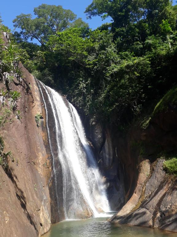 圣莱奥波尔迪娜Eco Parque Cachoeira Moxafongo的岩石峭壁边的瀑布