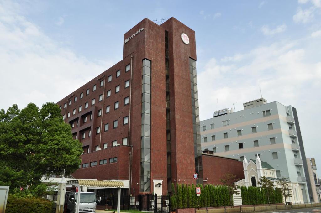仓吉市Kurayoshi City Hotel的一座高大的砖砌建筑,上面有时钟