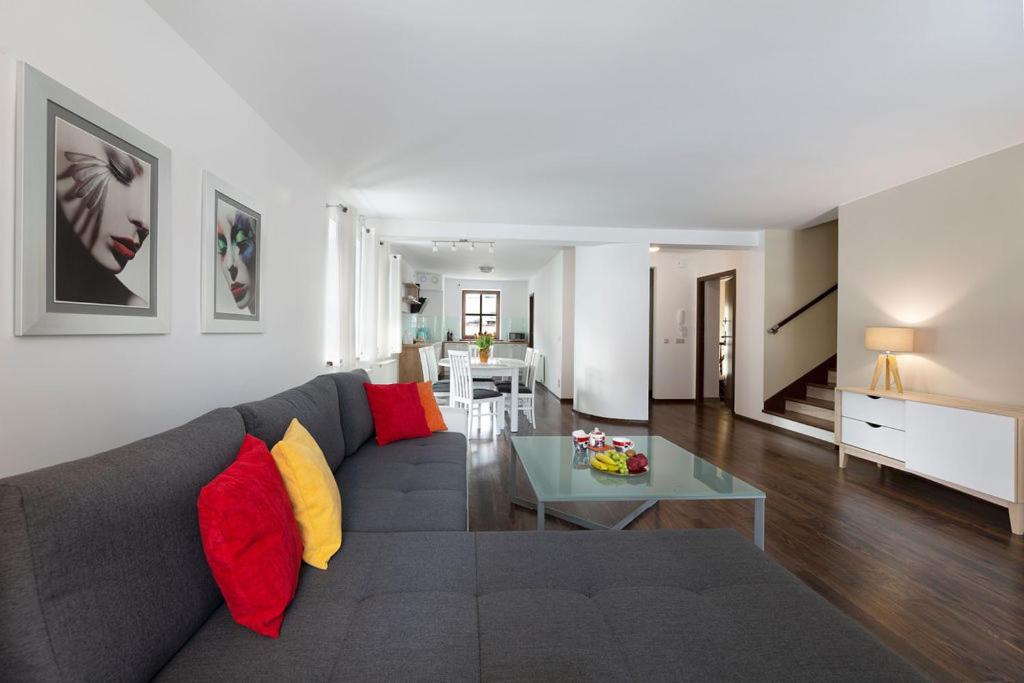 杜什尼基-兹德鲁伊Apartamenty KAPRYS的客厅配有带红色和黄色枕头的灰色沙发