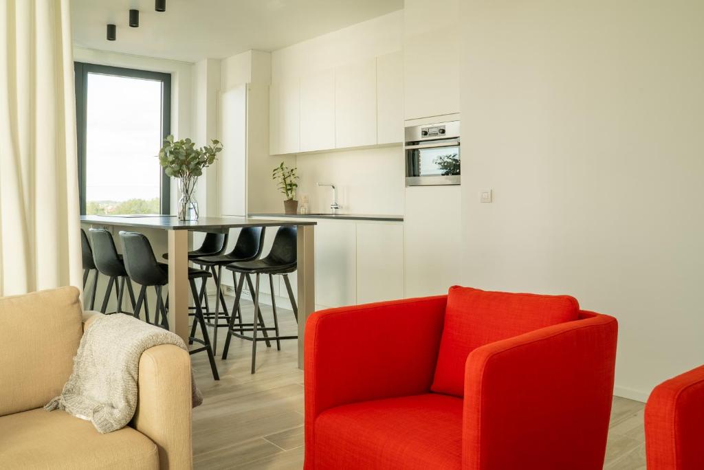 奥斯坦德Ostend Port Side incl parking的一间带红色椅子的客厅和一间厨房
