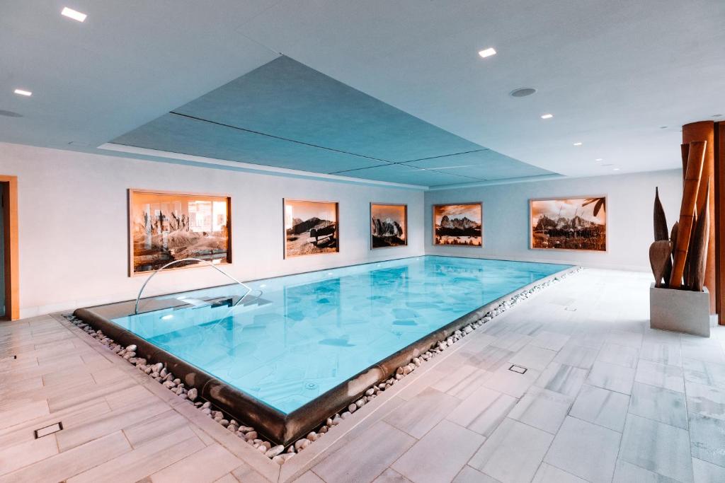 塞尔瓦迪加尔代纳山谷尼维斯精品酒店 - 多洛米蒂豪华设计的画室里的一个大型游泳池