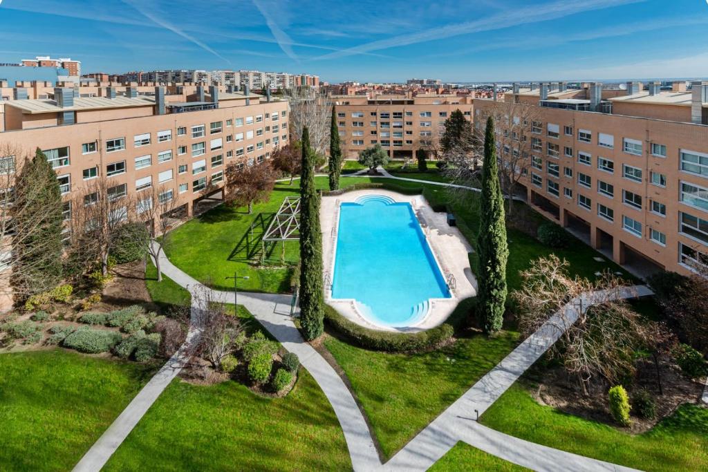 马德里Los Castaños Design Apartments in Conde Orgaz的享有公寓大楼的顶部景致,设有游泳池
