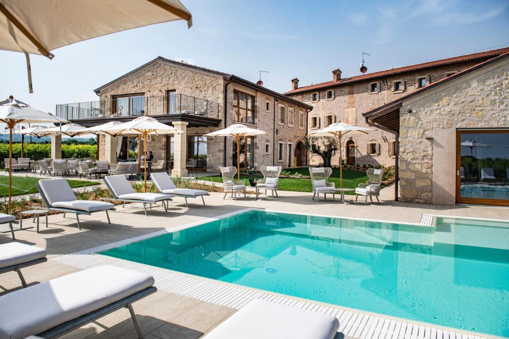 卡洛诺拉阿克里Magari Estates Hotel的别墅设有游泳池和庭院家具。
