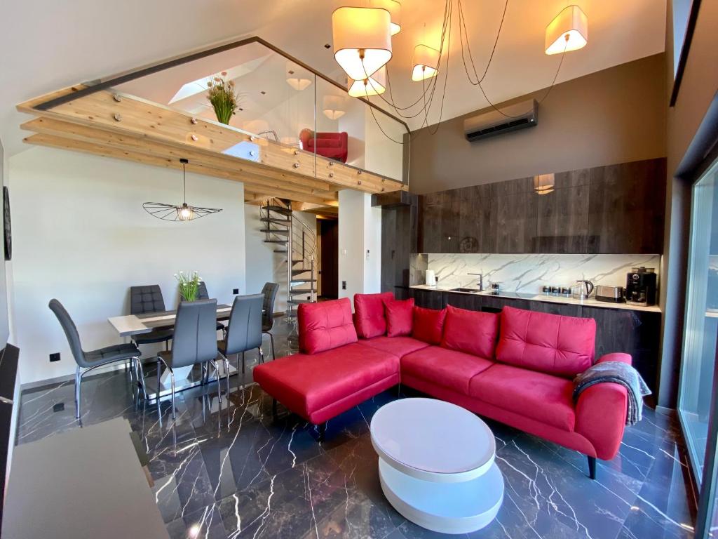乌斯特龙Apartament LUX Ustroń的客厅配有红色的沙发和桌子