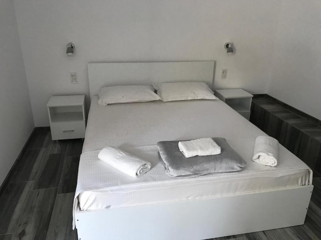 南埃福列CasaRiana 5的一张带两个枕头的白色床和毛巾