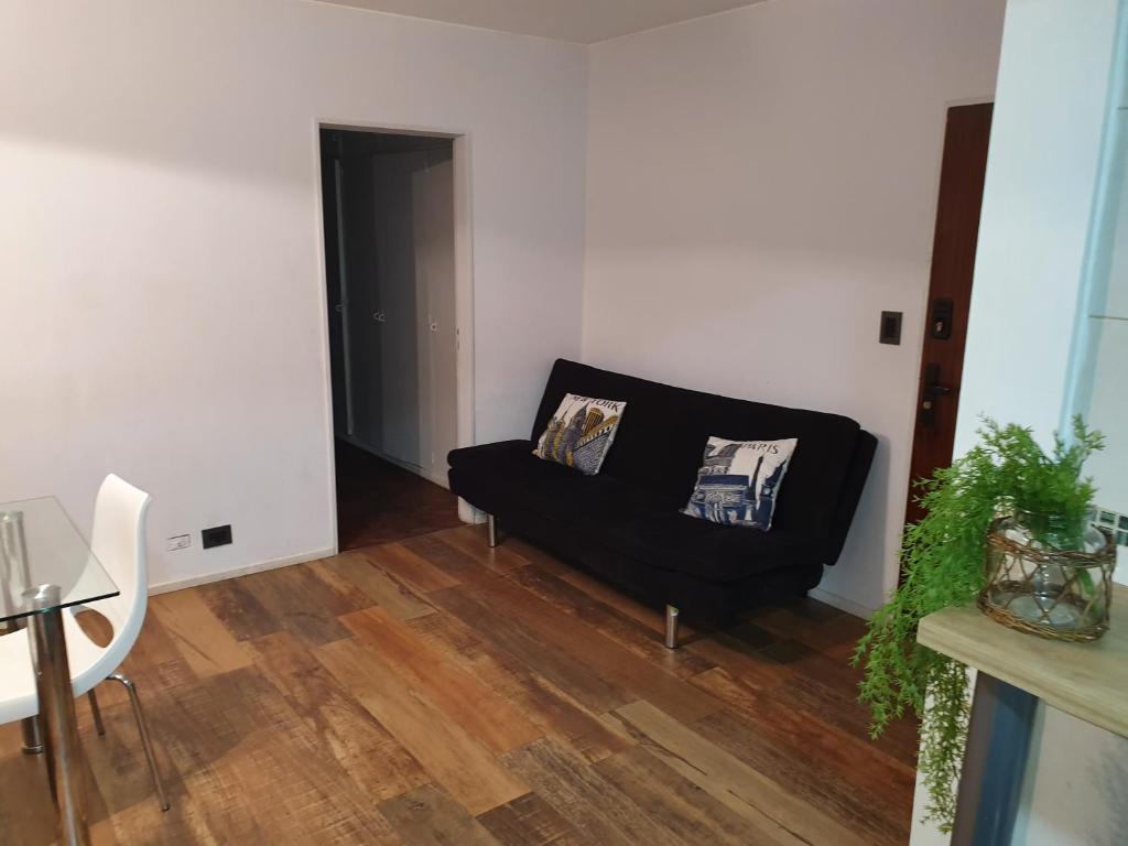 罗萨里奥Apartamento的客厅设有黑色沙发和木地板