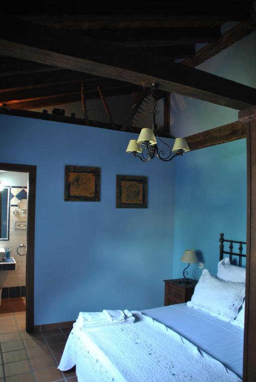 TenzuelaCasa Rural Los Regajales的一间卧室设有蓝色的墙壁和床