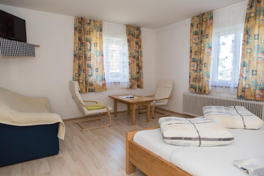 绍萨尔地区基策克Gästehaus Grasch的一间卧室配有两张床和一张桌子及椅子