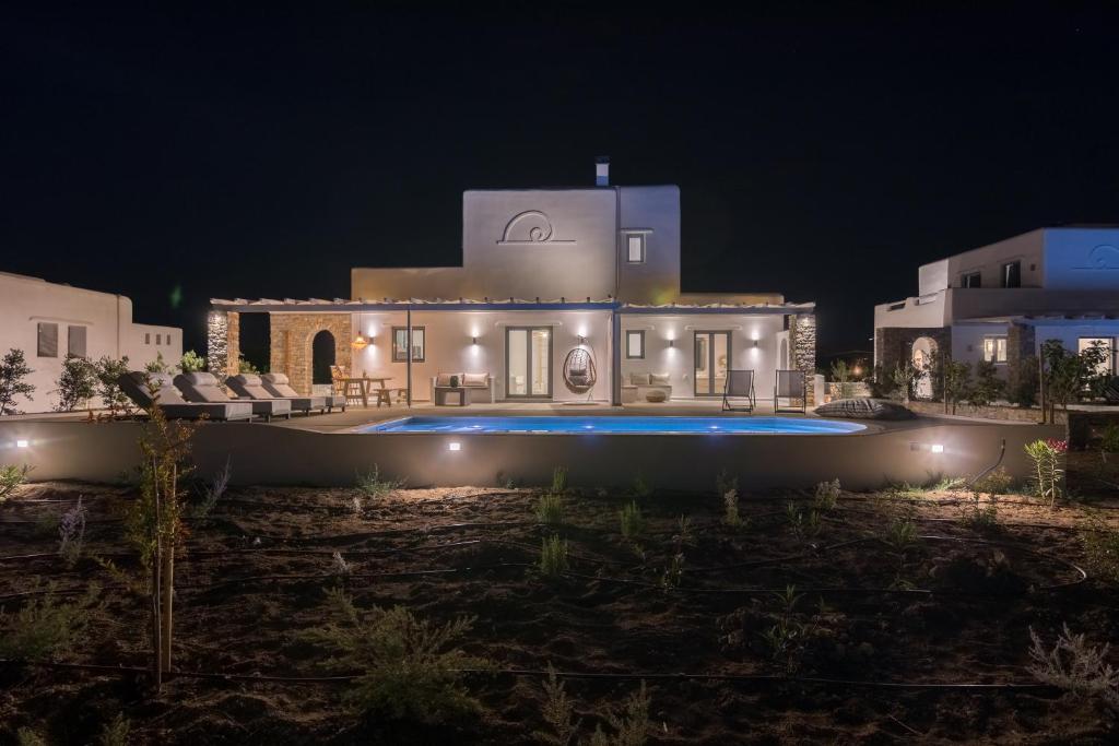 纳克索乔拉Isalos Villas Naxos的夜间带游泳池的别墅