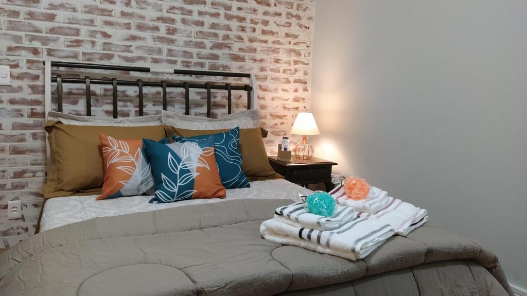 特雷索波利斯Casa Verde - Suíte 2 - Iúcas, Teresópolis, RJ的一间卧室配有带枕头的床和砖墙