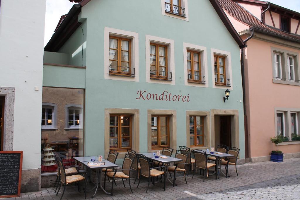 罗滕堡厄赫酒店的大楼前设有桌椅的餐厅