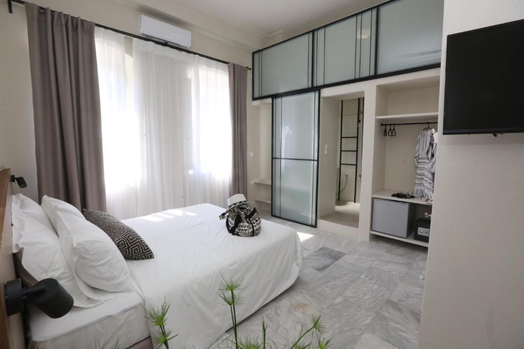 埃尔莫波利斯OIKO MINI SUITES的卧室设有白色的床和大窗户
