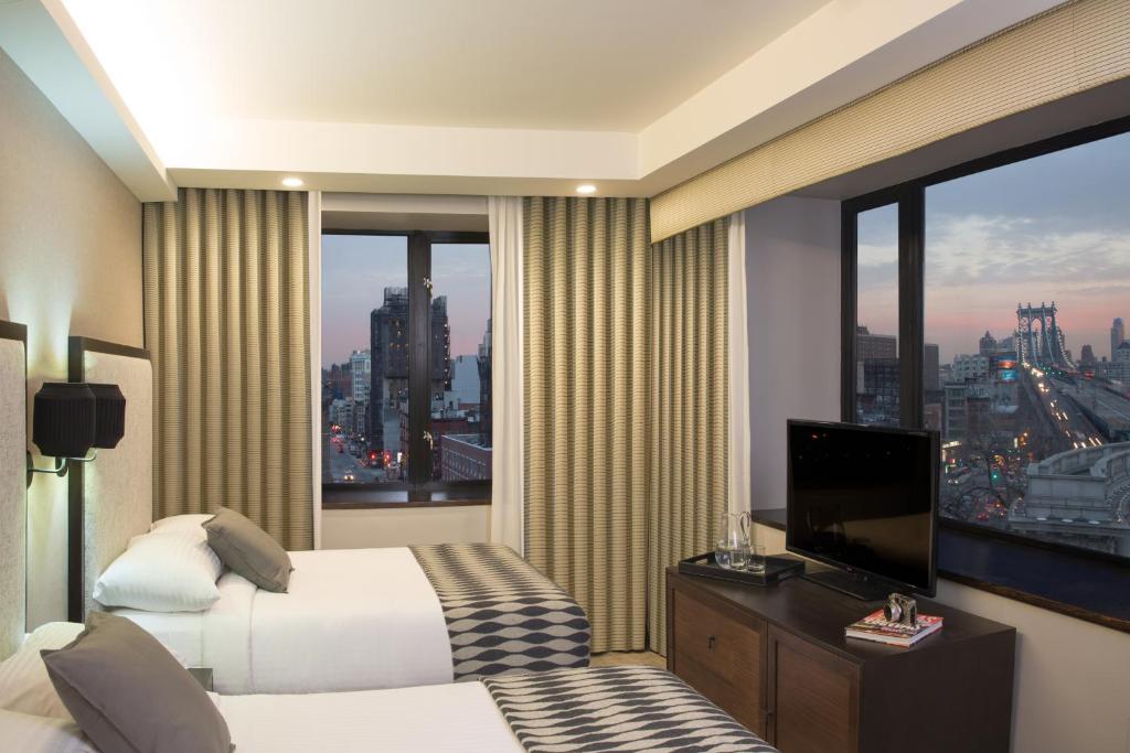 纽约Leon Hotel LES的酒店客房设有一张床和一个大窗户