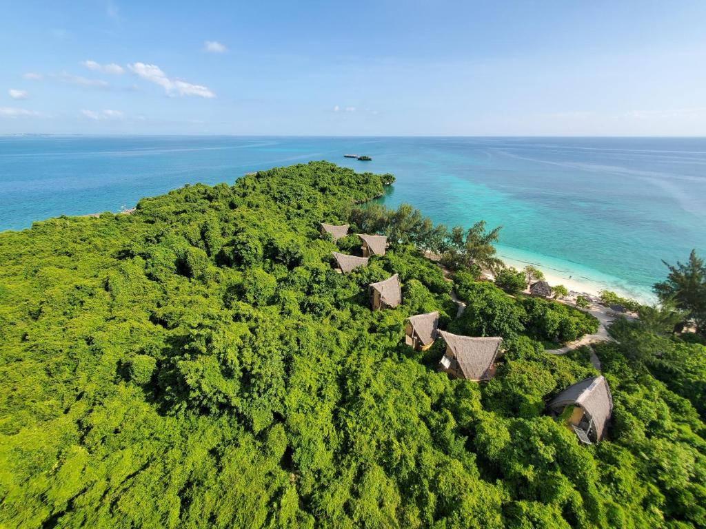 Mbweni琼碧岛珊瑚礁公园度假村的享有热带岛屿的空中景致,设有房屋和海洋