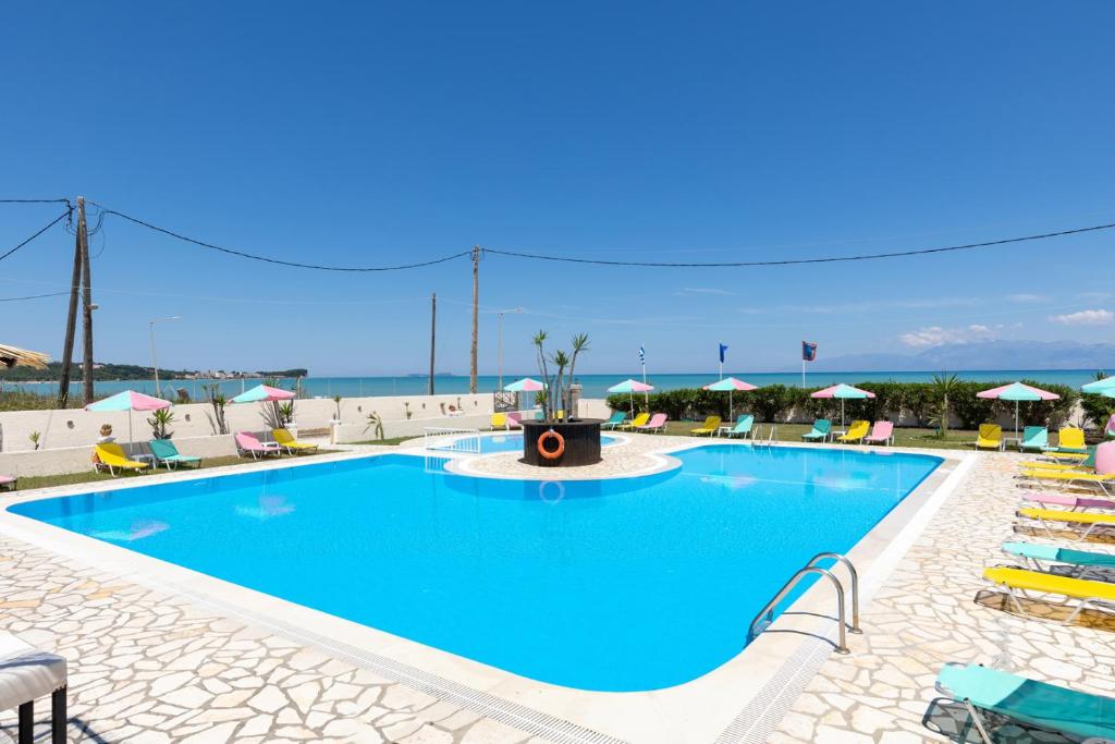 罗达Amorossa Beachfront Village by Konnect, Roda Corfu的一座大型游泳池,在海洋前方设有喷泉