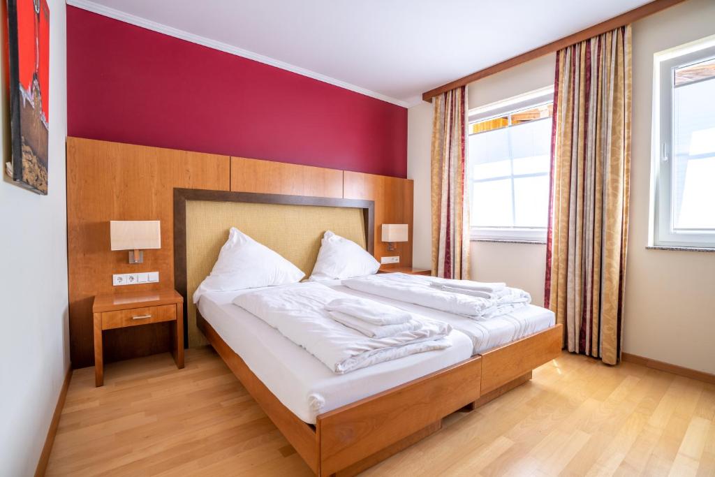 尼特尔Mühlengarten by Relax Inn - Staffless & Self Check-In的一间卧室配有一张带白色床单的大床