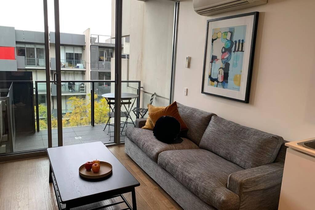 墨尔本Sunny Balcony Over a Calm Private Garden的客厅配有沙发和桌子