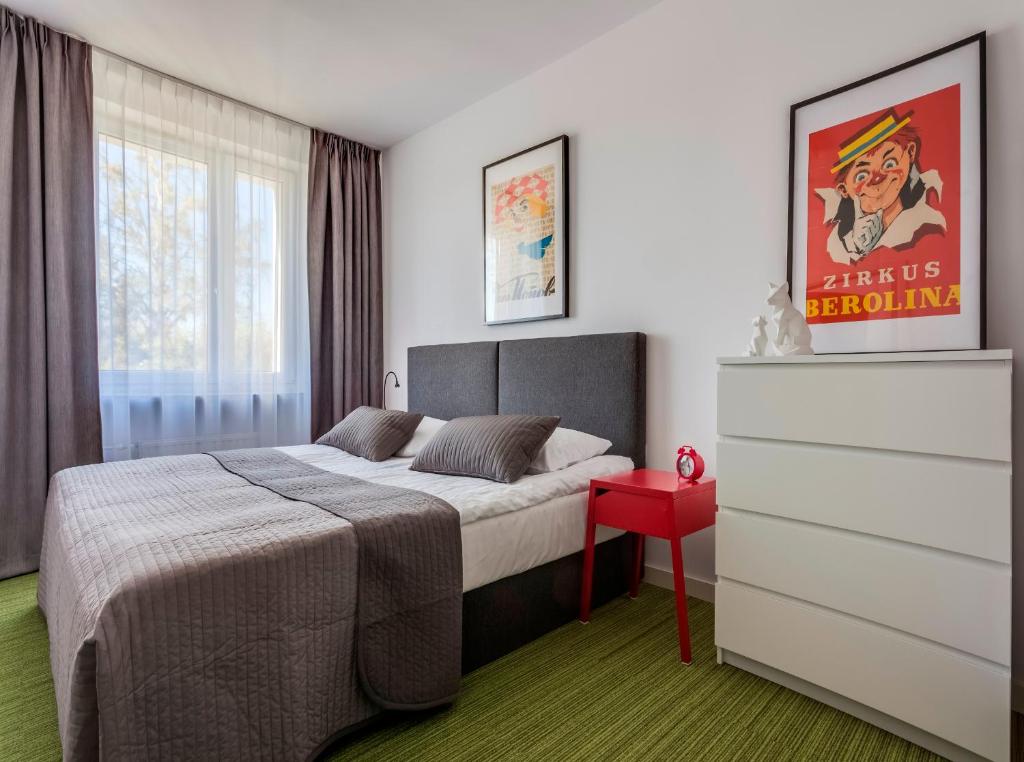 LesznoB&B Julinek Park的一间卧室配有一张床和一张红色的桌子