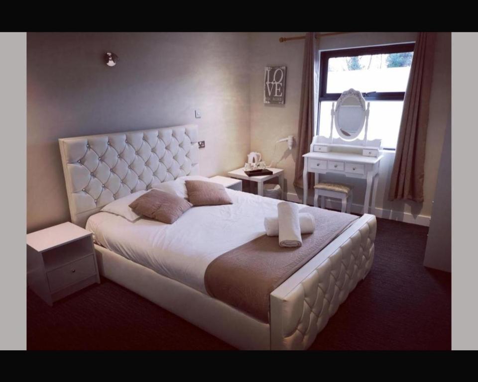 DesboroughThe R Inn Hotel的卧室配有一张白色大床和镜子