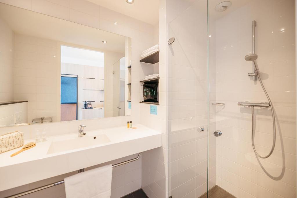 阿姆斯特丹阿姆斯特丹之家酒店的白色的浴室设有水槽和淋浴。